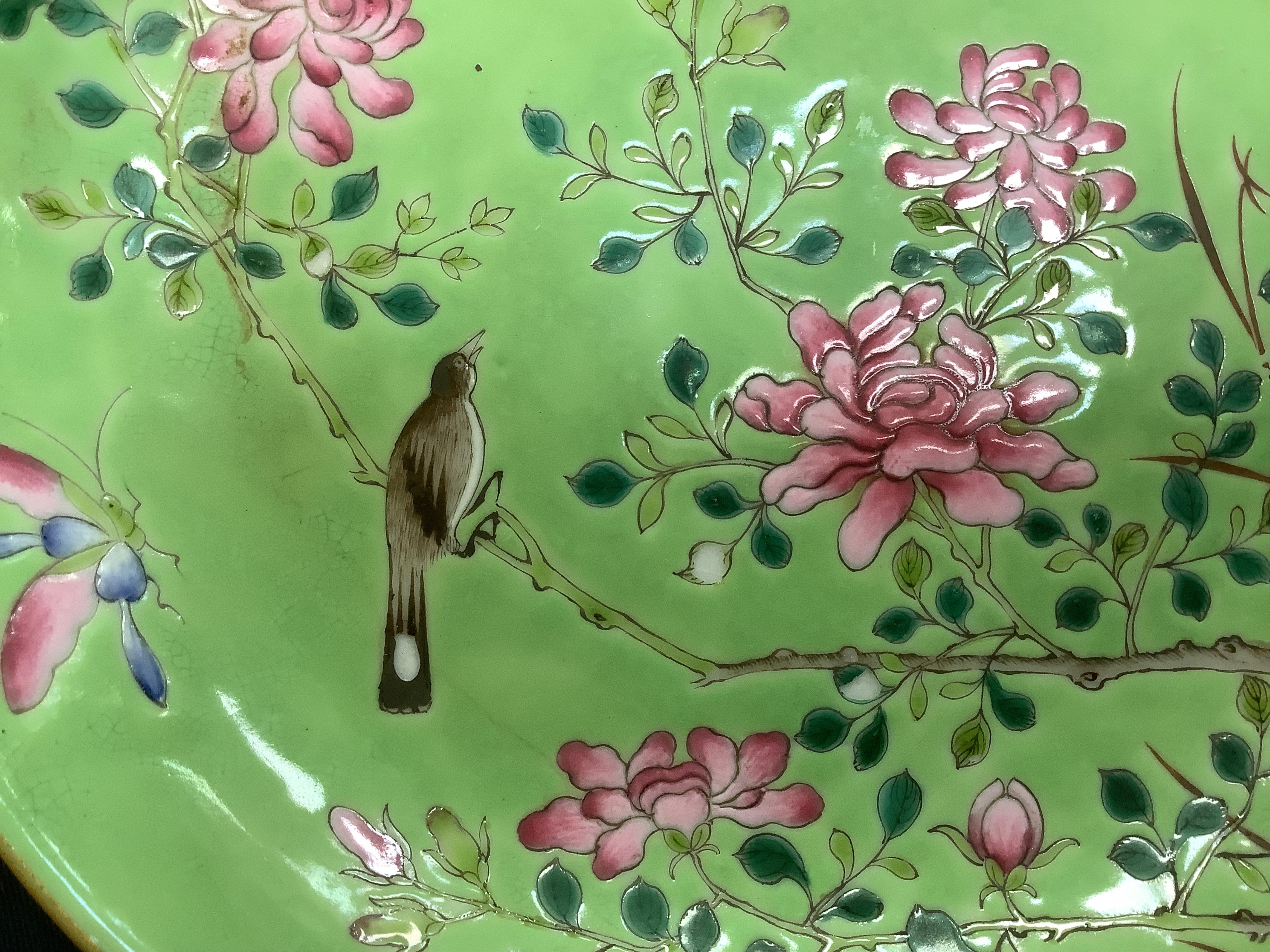 A Chinese famille rose and green ground dish decorated with birds amongst flowers, 17cm in diameter